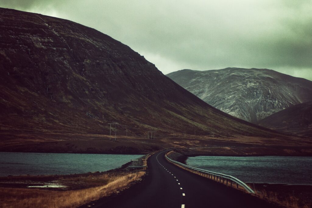 concrete bridge near mountains during daytime