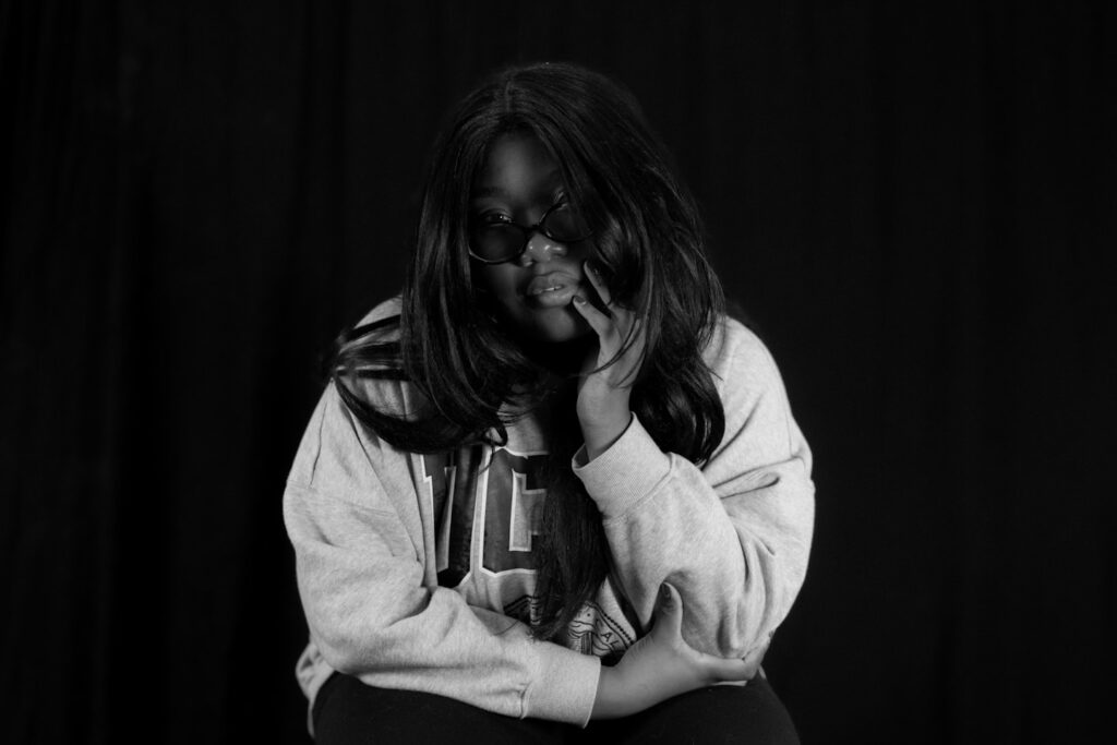 A young woman with dark hair resting her head.